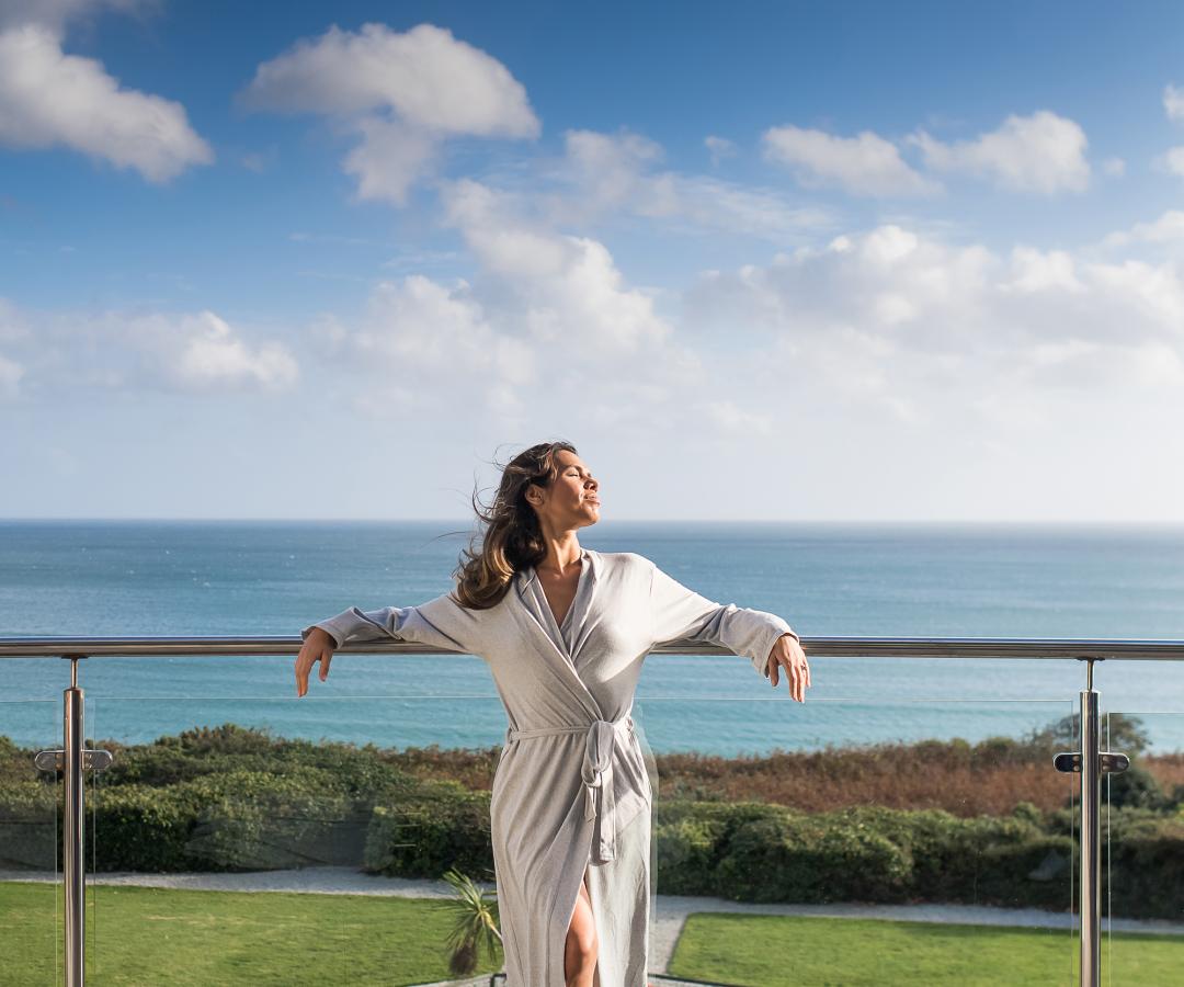 On on balcony with sea in the background